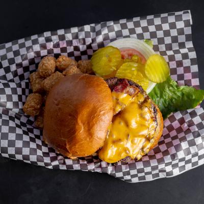 Bacon Deluxe Burger served with tater tots.