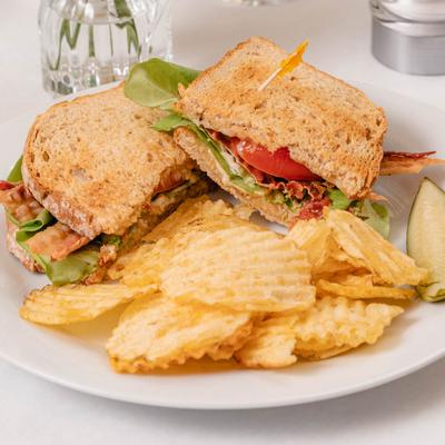 BLT sandwich, with a side of potato chips.