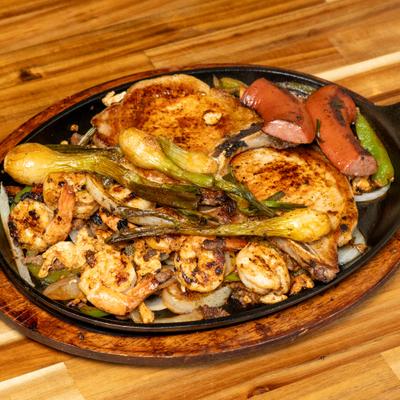 Grilled chicken, shrimp, sausages, onions, and peppers.