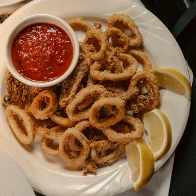 Fried calamari with dip and lemon wedges.