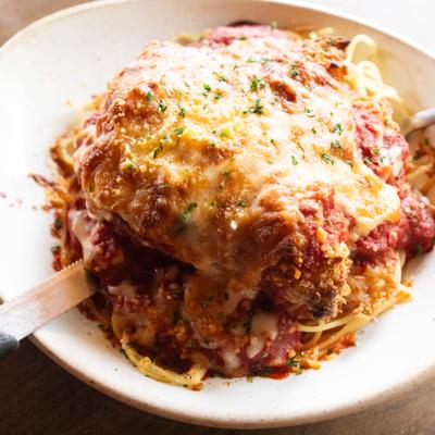 Fried Chicken Parmesean topped with melted cheese and served over spaghetti.