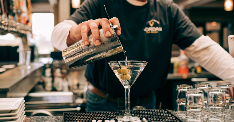 Bartender pouring a cocktail from shaker