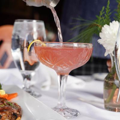 A cocktail being poured in a glass.