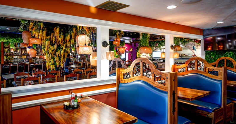 Colorfully decorated restaurant interior with blue upholstered booths, polished wooden tables