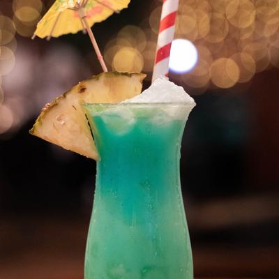 Detroit hurricane, garnished with pineapple wedge, cocktail umbrella, candy cane.