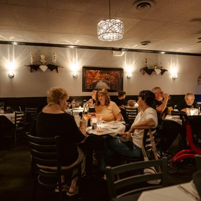 People sitting at the tables, having drinks and food.