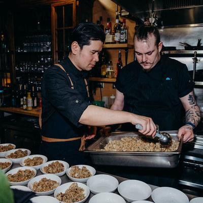 Chef scooping fried rice from a metal tray.
