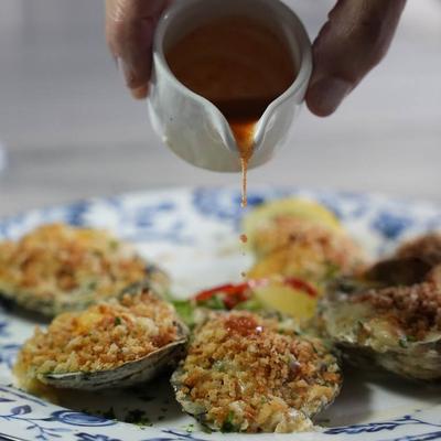 Baked clams with sauce drizzle.