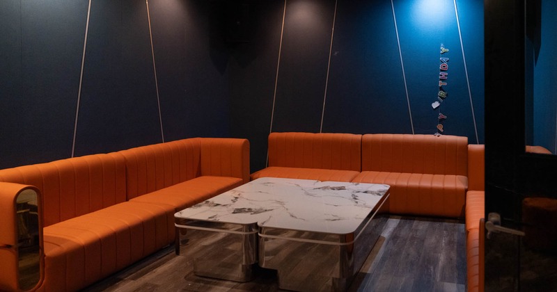 Interior, lounge area, large orange leather padded sofas, large marble top coffee table