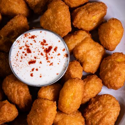 Sweet corn fritters served with creamy white dipping sauce.
