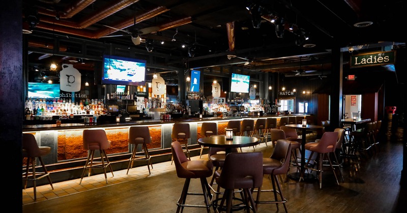 Bar area with tables and chairs and bar in the back