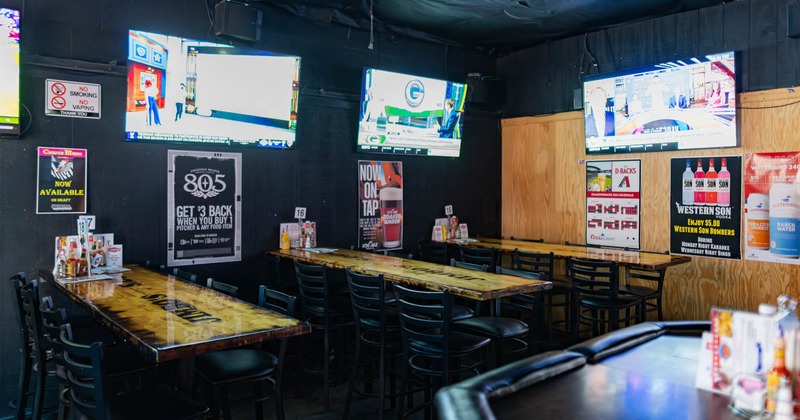 Tall tables, bar stools and TVs on the walls