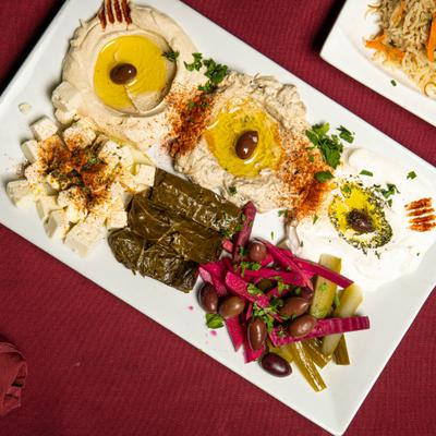 Hummus, baba ghanoush, grape leaves, kabis, feta cheese, labneh, and olive oil.