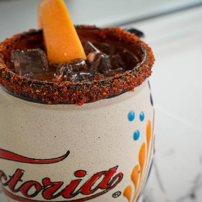 Tajin rimmed cocktail in a clay cup.