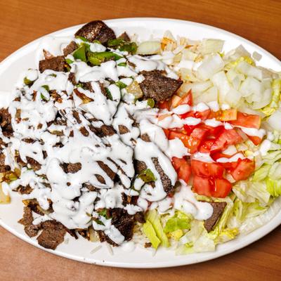 BBQ Chicken served over rice, drizzled with white sauce, with side salad.
