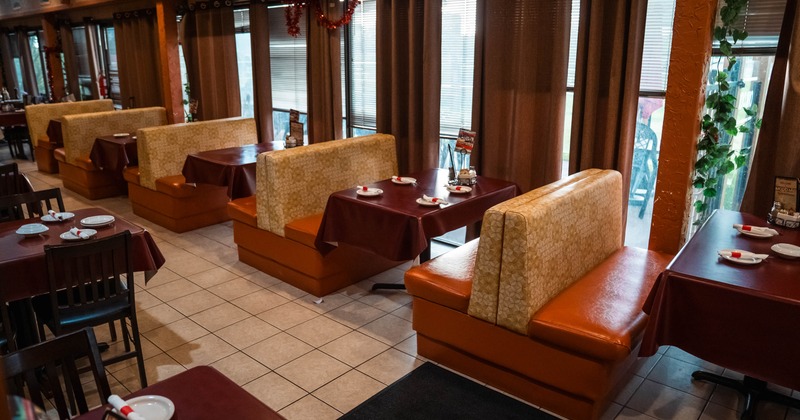 Interior, dining area, seating booths with maroon cloth tables, tile flooring