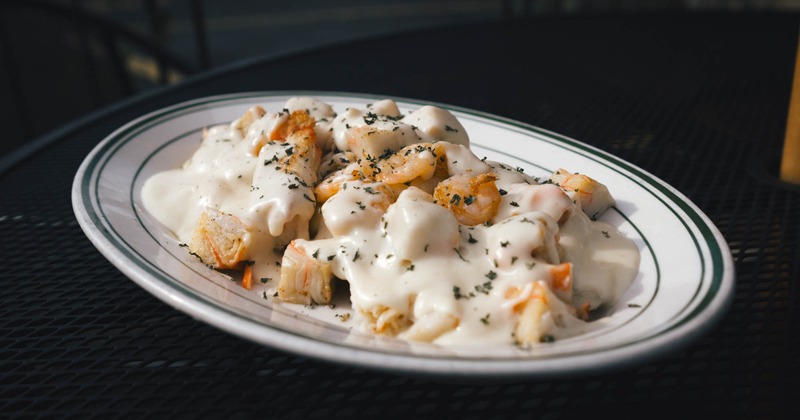 Shrimp and Crab Ravioli, topped with shrimp, crab meat, and white sauce