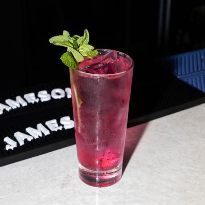 A refreshing purple drink garnished with mint leaves.