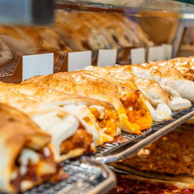 Assorted calzones in a display case.