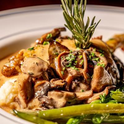 Duck leg with creamy mushroom sauce and green beans.