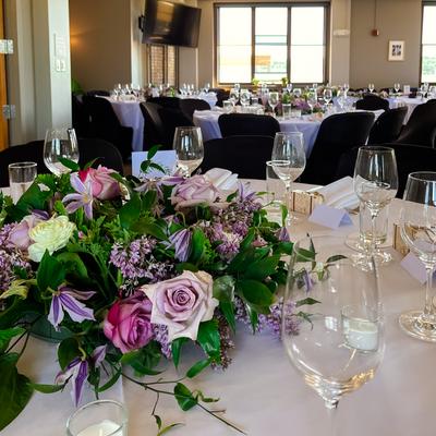 Interior, dining area, round tables with floral centerpiece, closeup
