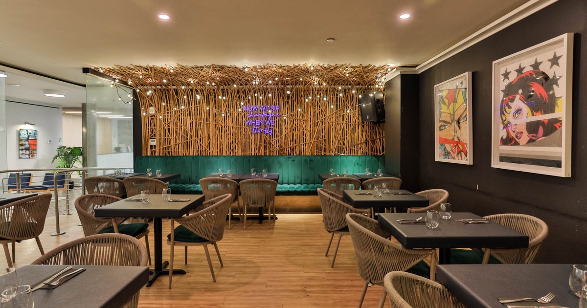 Interior, seating area with tables, chairs and booths in the back