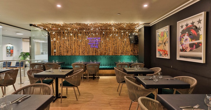 Interior, seating area with tables, chairs and booths in the back