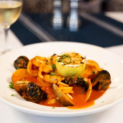 Seafood soup with clams, jumbo shrimp, calamari and mussels, garnished with grilled lemon.