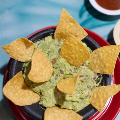 Serving of guacamole and chips.