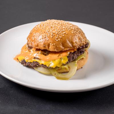 The Huda Burger with grilled onions, cheese and sauce on a sesame seed bun.
