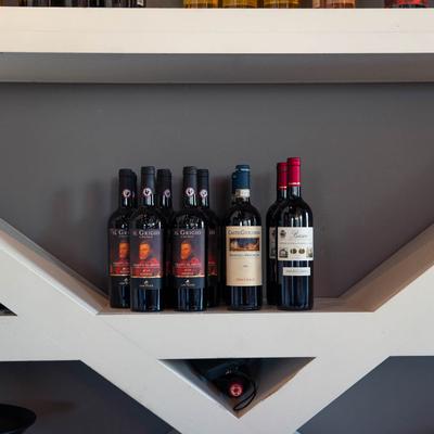 Italian wine bottles on a shelf.