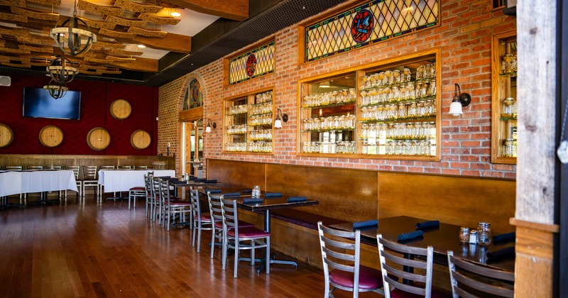 Interior seating area with brick walls, wooden tables and decorative stained glass