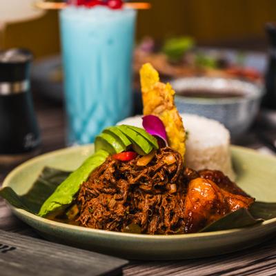 Shredded beef dish with avocado, rice, and fried plantain.