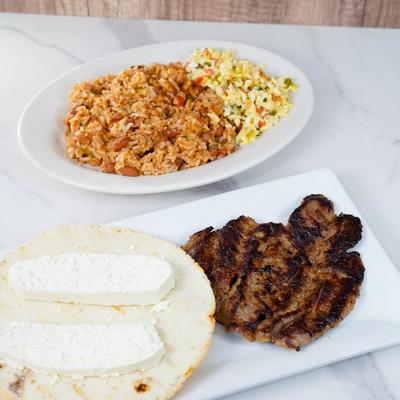 Steak, rice with beans and beef, eggs, flat maize bread and Colombian cheese.
