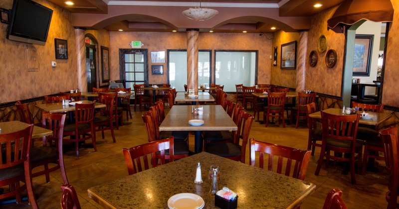 Restaurant interior, tables and chairs arranged in the middle of dining area
