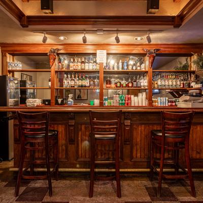 Front view of a bar with spirits on the bar shelves.