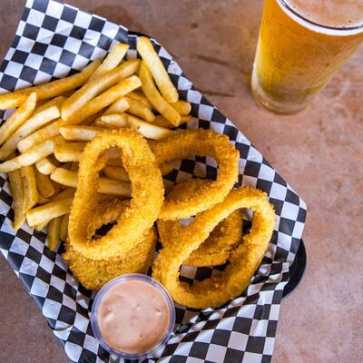 Onion rings, fries, glass of beer on the side