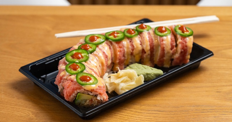 Crazy Phoenix Roll served in a black takeout tray