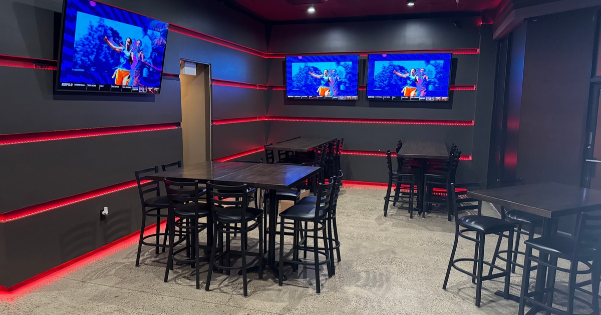 Interior with tables, chairs, TVs, and red LED lights