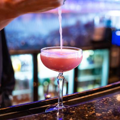 Peach raspberry cocktail being poured.