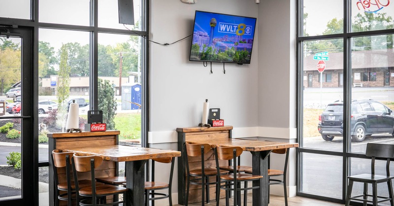 Two tables in the corner next to the restaurant's large windows