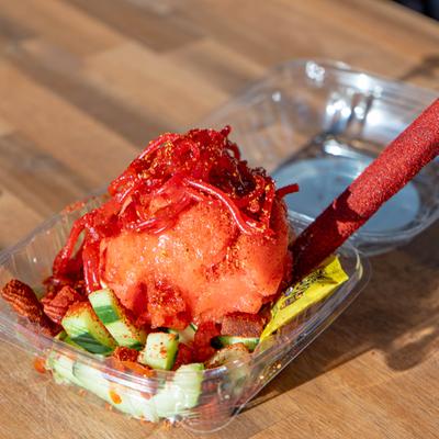 Frozen dessert topped with gummy candy strips and a tamarind stick.