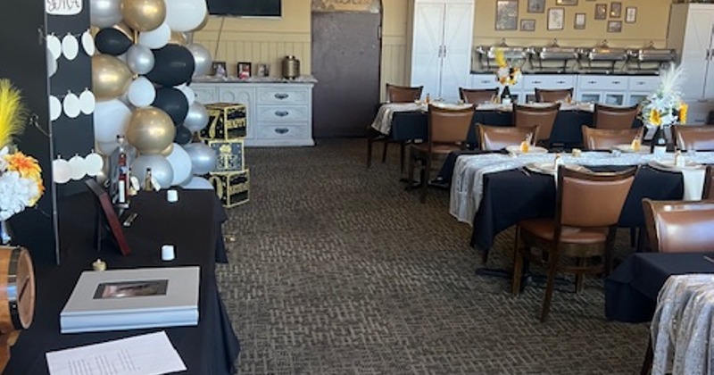 Interior with red and white checkered tablecloths and black cushioned seating