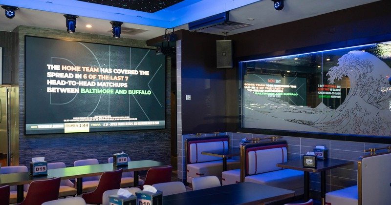 Interior, dining area, booths with tables, regular tables and chairs, large projector screen