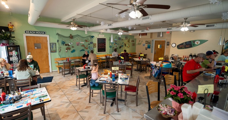 Interior featuring both table and counter seating and beach-themed decor