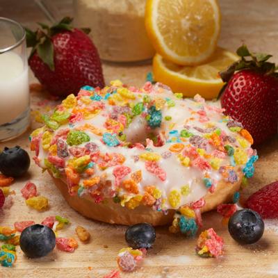 Donut topped with vanilla icing and Fruity Pebbles.
