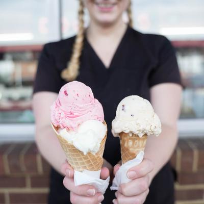 staff member holding 2 ice cream cones.