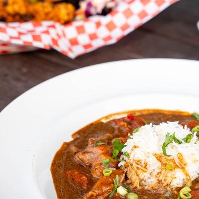Jambalaya served on the table alongside other meals in the background.