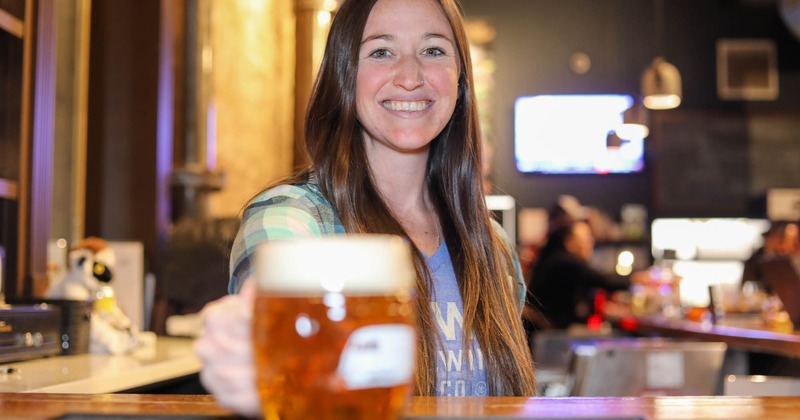 Staff serves a glass of beer behind the counter