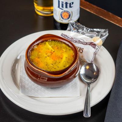 Chicken noodle soup served with crackers.